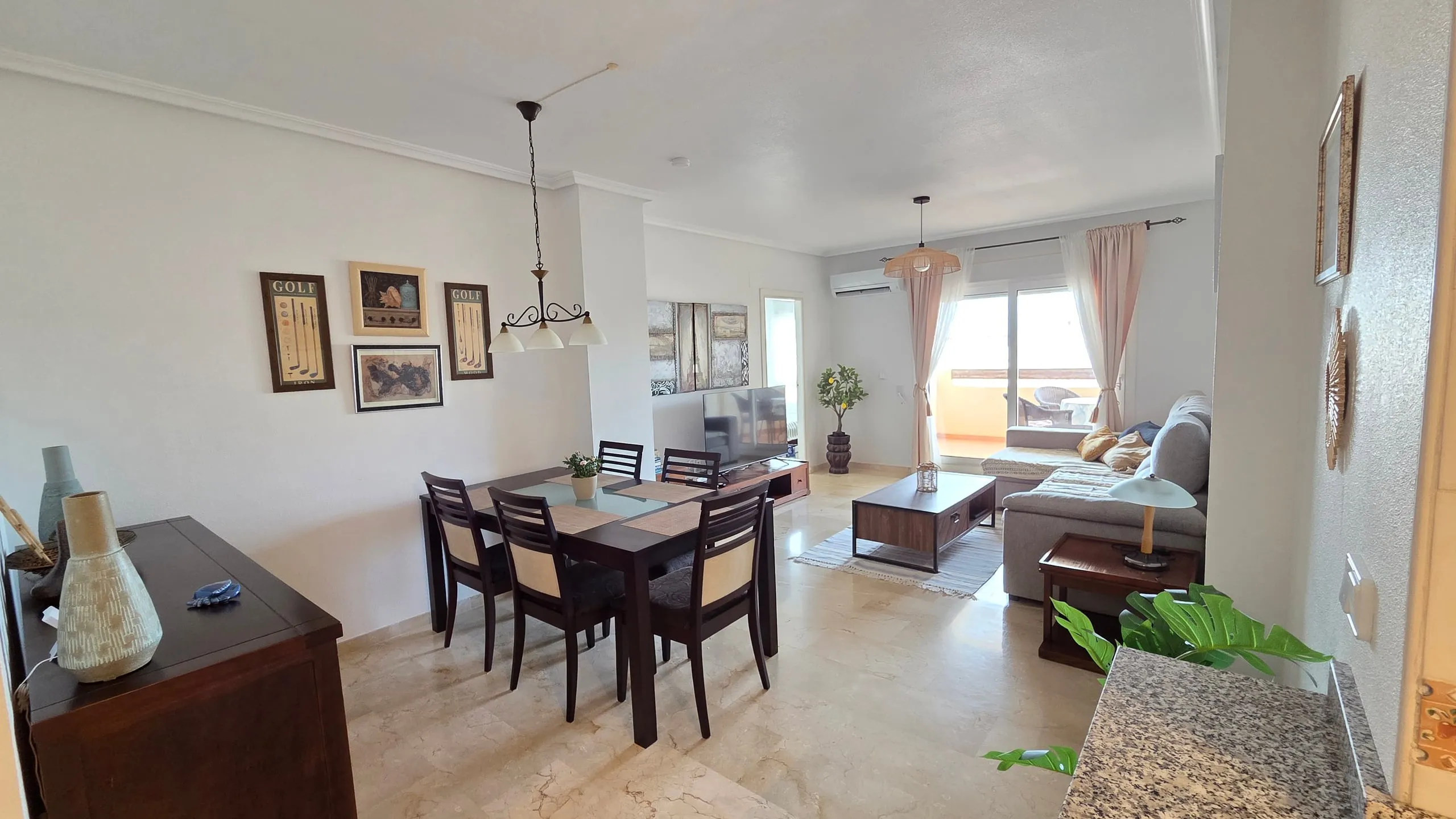 Dining table and living area with door to the balcony